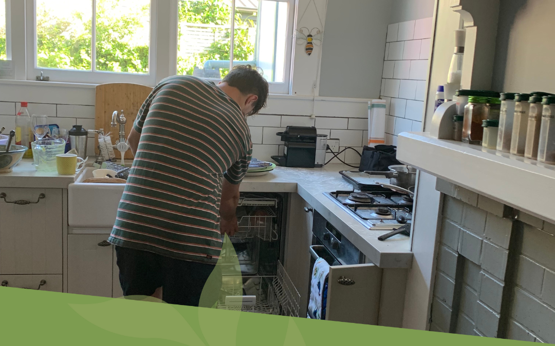 Male adolescent tidying the kitchen